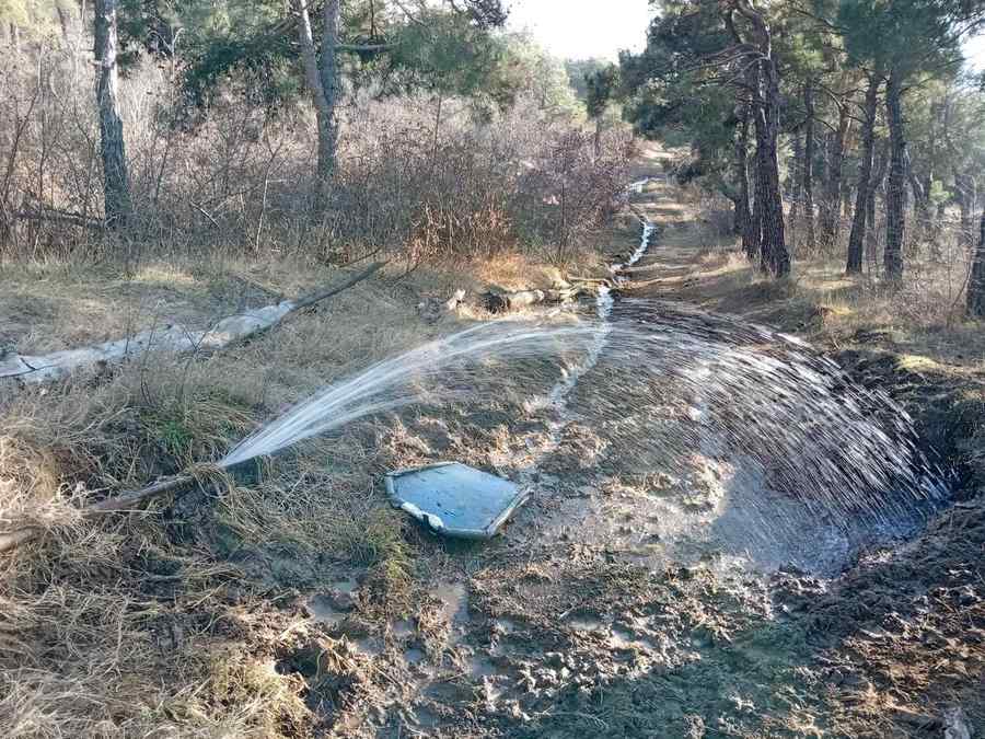 Water leaking from a broken pipe near a foundation